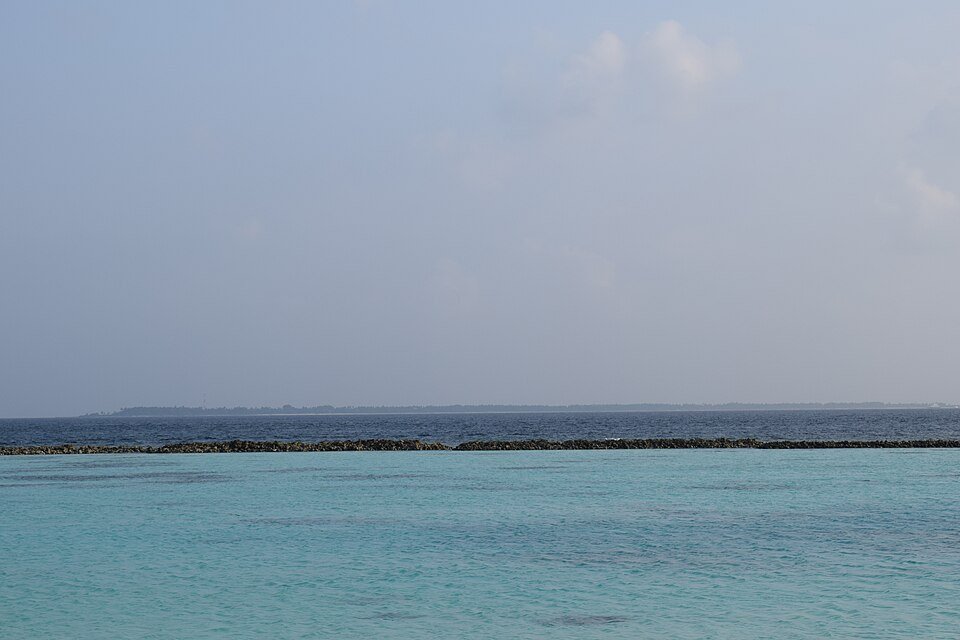 Dhigurah on the distant horizon beyond coastal water