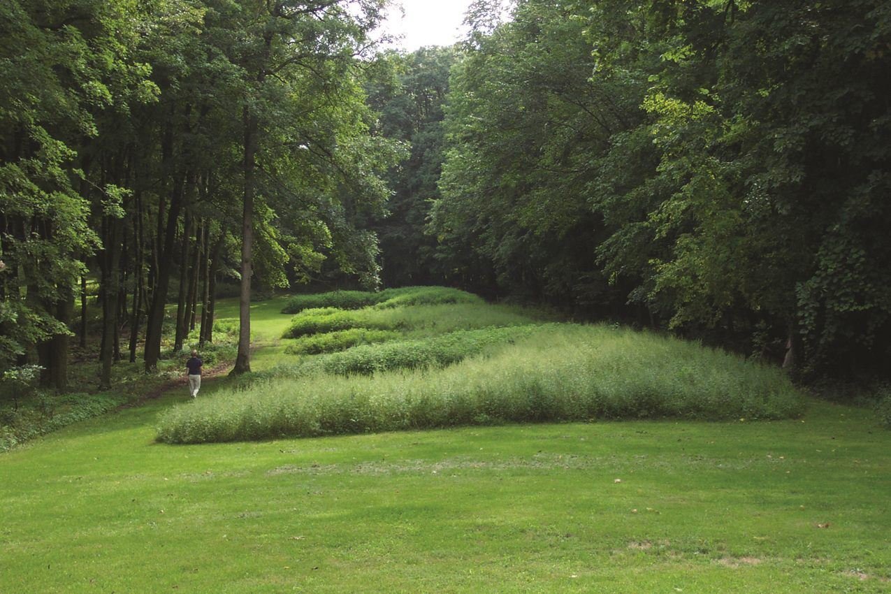 Bear Effigy Mounds with visitor walking nearby. 