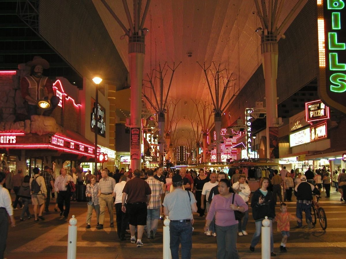 Throngs of people move under the covered structure while the neon lights up the night at Fremont.