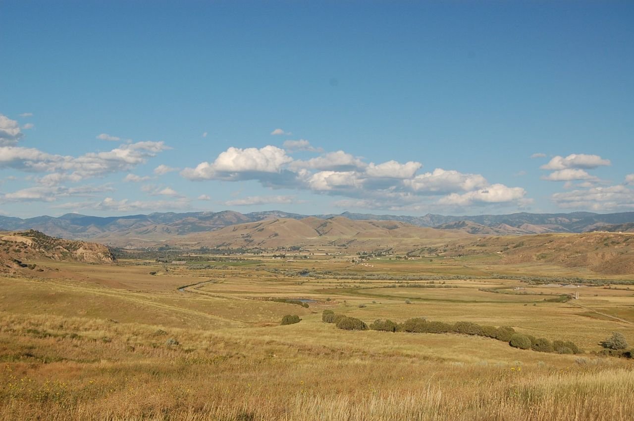 The long valley of the Bear River stretches east toward the mountains, as seen from the upper parking area of the Bear River Massacre National Historic Site.
