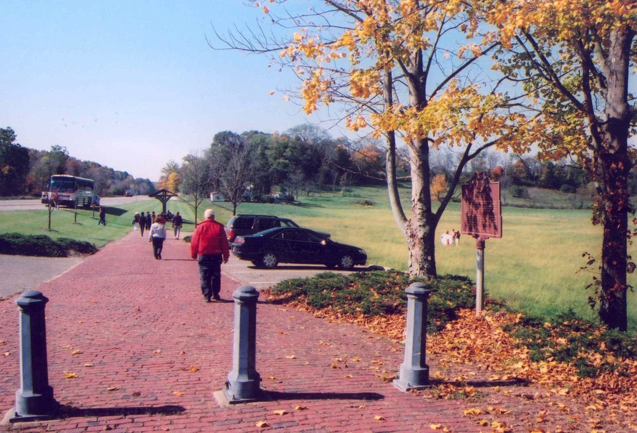 A few people walk west near the Fox Run S-Bridge on the original alignment of the National Road in Ohio.