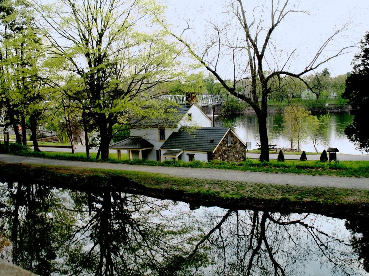 Parallel ribbons of history can be seen - the Delaware and Raritan Canal with its multiuse path and historic buildings (such as the Ferry House used during the Christmas morning crossing of George Washington) and the calming flow of the Delaware River. Nearby Pennsylvania can be seen in the background, connected by a historic bridge.