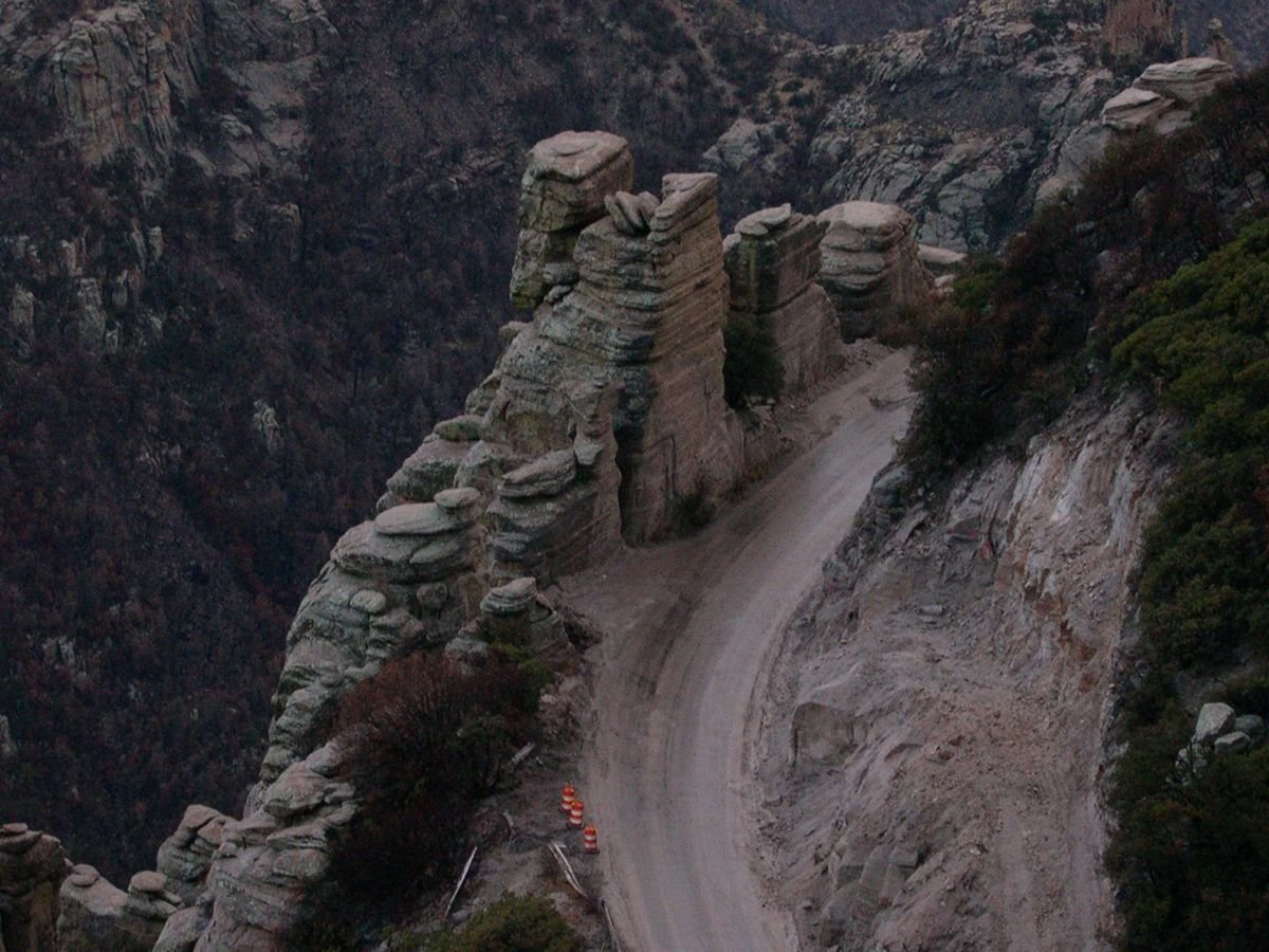 The Sky Island Parkway features a daunting view of the sheer cliffs that line the highway. Road-construction cones warn drivers away from a damaged railing in this photo.