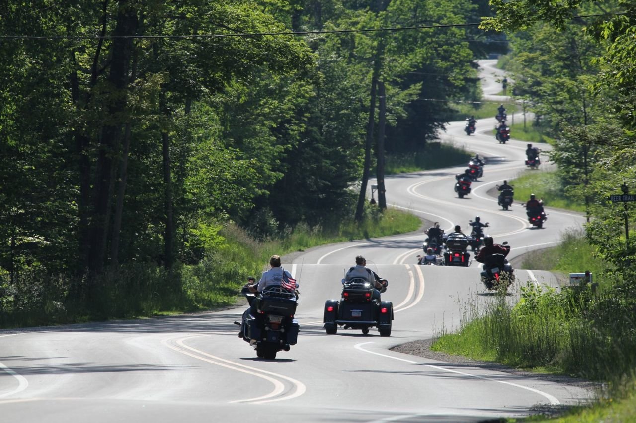 A group of motorcyclists riding two-wheeled and three-wheeled bikes are enjoying the 15 curves of a segment of Wisconsin Highway 42. The highway’s configuration is perfect for recreational drivers to enjoy the beauty of the natural world in all seasons.